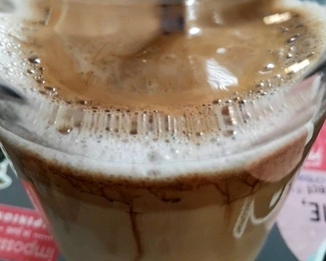 Dalgonakahvi, jossa ohut kahvivaahto, joka osittain painuu kauramaidon sekaan.