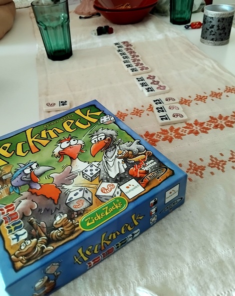 Etualalla Heckmeck -peli, taaempana pelinappuloita pöytäliinalla