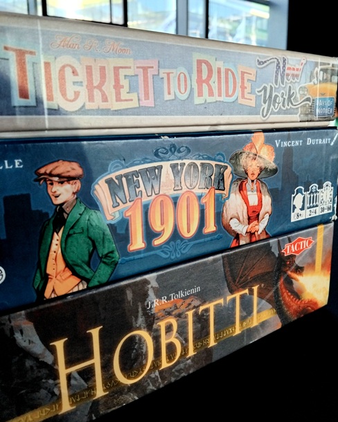Lautapelien laatikoita. Kuvassa Menolipun New York-versio, New York 191-peli ja Hobitti-peli